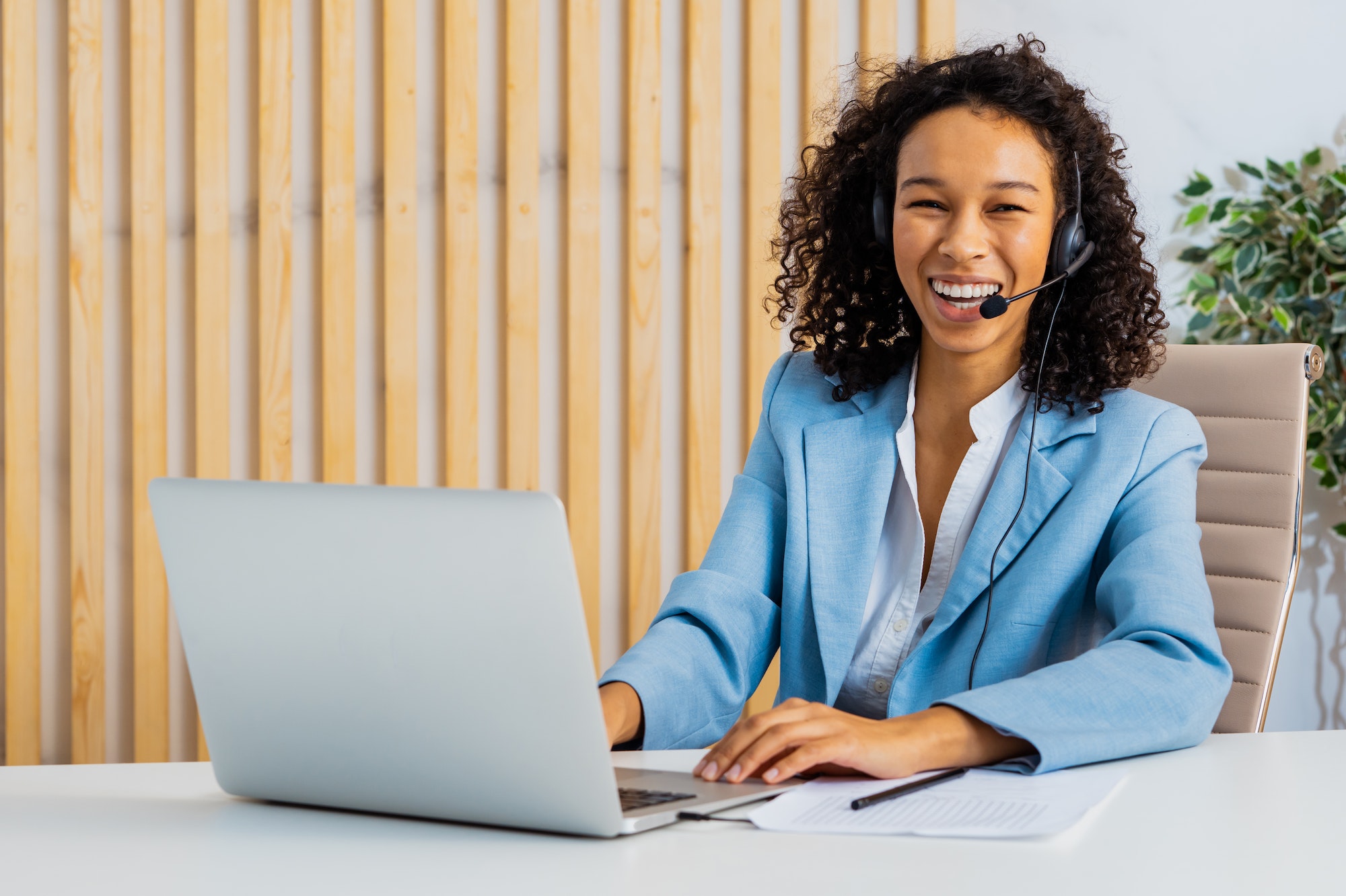 Businesswoman Sitting At Computer Desk In The Office With Microphone Headset